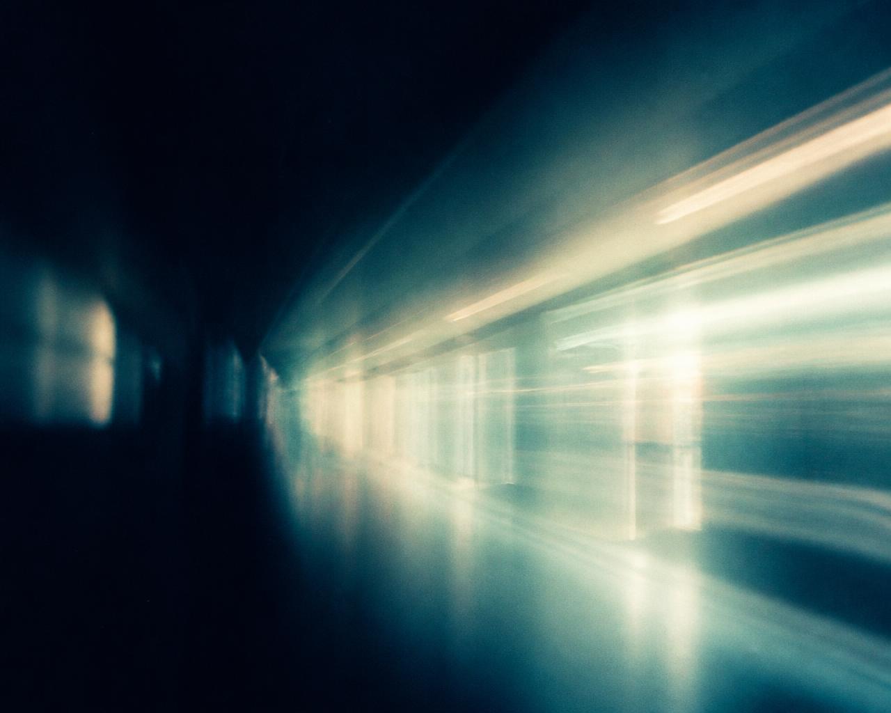 Abstract composition of soft teal hospital light moving through darkness, standing in for future portrait photography